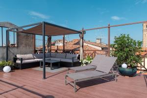 un patio avec un canapé et un parasol sur le toit dans l'établissement La Finestra sulle Beccarie, à Venise