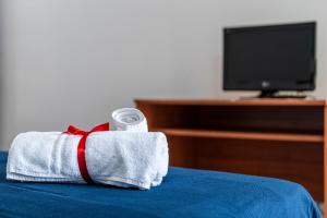 un asciugamano con una bottiglia d'acqua poggiata sopra un letto di CATONA HOUSE a Otranto