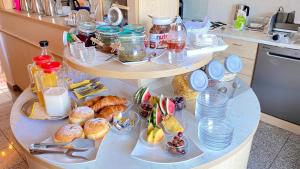 a table with three shelves filled with breakfast food at Villa Osipovica in Medulin