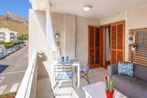 einen Balkon mit einem Sofa und einem Tisch in der Unterkunft Aire del Mar in Pollença