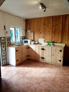 a kitchen with wooden cabinets and a white refrigerator at Estudio Tanner in Pedrógão Grande