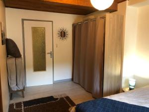 - une chambre avec un lit et une porte avec un miroir dans l'établissement le petit champliman, à Ornans