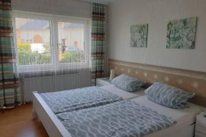1 Schlafzimmer mit 2 Betten und einem Fenster in der Unterkunft Ferienwohnung Christina in Hinterweiler