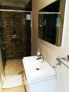 a bathroom with a sink and a mirror at A' Queenslin Guesthouse in Paarl