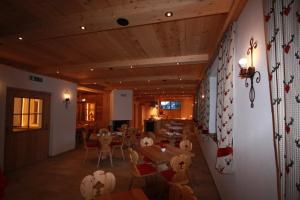 un restaurant avec des plafonds en bois, des tables et des chaises dans l'établissement Landgasthof Kirchenwirt, à Krimml