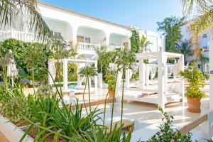 un patio con plantas y un edificio blanco en Beach Star Ibiza, en Bahía de San Antonio