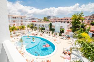 a beach with a pool, chairs, and a large swimming pool at The Beach Star Ibiza - Adults Only in San Antonio Bay