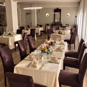 una sala da pranzo con tavoli bianchi e sedie viola di Hotel Atlantico a Forte dei Marmi