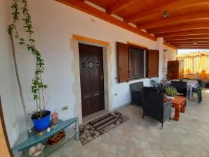 uma sala de estar com uma porta e uma mesa e cadeiras em Vacanze da Macandu & Stefi em San Giovanni Suergiu