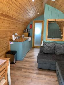 una habitación con sofá y una cocina en una cabaña en Kersebrock Kabins en Falkirk
