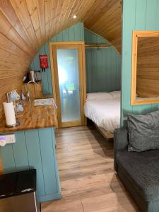 Habitación pequeña con cama y sofá en Kersebrock Kabins, en Falkirk