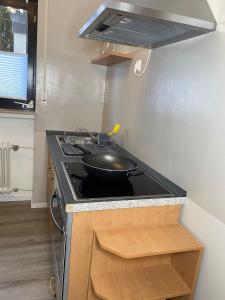 a kitchen with a stove with a frying pan on it at Ferienwohnung Birkenhof in Drolshagen