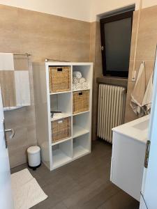 a bathroom with a white cabinet with baskets and a television at Ferienwohnung Birkenhof in Drolshagen