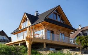 una casa in legno con tetto a gambero di Domek Nad Doliną a Orawka