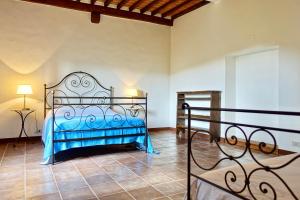 um quarto com uma cama de metal num quarto em Casa alla Vecchia Posta di Bagno Vignoni em Bagno Vignoni