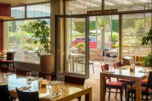 a restaurant with tables and chairs and a patio at Wellness Hotel ABÁCIE Nový Jičín in Nový Jičín
