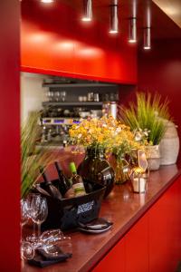 新伊欽的住宿－阿巴西亞療養酒店，一个带酒瓶和玻璃杯的柜台,并有鲜花