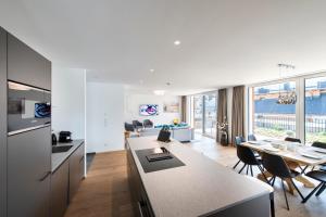 MANNI village - lifestyle apartments في مايرهوفن: مطبخ وغرفة معيشة مع طاولة وكراسي