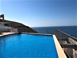 a swimming pool with the ocean in the background at Villamarina dúplex en primera línea de mar - Fincas Arena in Benidorm