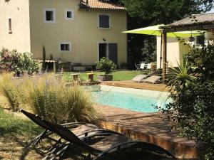 a backyard with a swimming pool and a house at Mas des Rabasses in Le Pontet