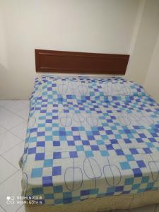 a bed with a blue and white checkered mattress at Pangkor fun fun fun apartment in Pangkor