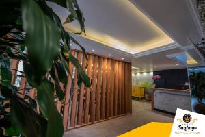 a lobby with a wooden fence and a table at Hotel Santiago Centro in Teresópolis