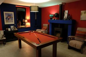 uma sala de estar com uma mesa de bilhar e uma lareira em La Maison Jaune à la Janaie em Parigné