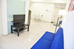 Gt Home encorp strand residence (alpha ivf ) في كوتا دامانسارا: غرفة معيشة مع أريكة زرقاء وطاولة