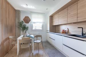 a kitchen with white cabinets and a table and chairs at Bilbao Sensations.OLD TOWN exclusive views&parking in Bilbao