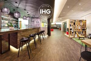 ein Restaurant mit einer Bar mit Hockern in der Unterkunft Holiday Inn Express Hasselt, an IHG Hotel in Hasselt