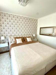 a bedroom with a large white bed in a room at Die Oase - Luxurious Apartment near the City Center with Free Parking in Bratislava +10 photos