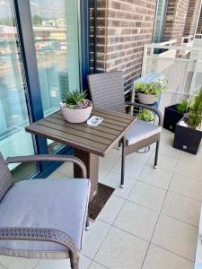y balcón con mesa y sillas de madera. en Die Oase - Luxurious Apartment near the City Center, en Bratislava
