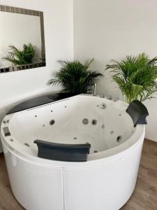 a white bath tub in a room with potted plants at Die Oase - Luxurious Apartment near the City Center in Bratislava