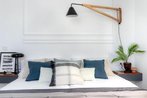 a bedroom with a bed with blue and white pillows at Bilbao Sensations.OLD TOWN exclusive views&parking in Bilbao