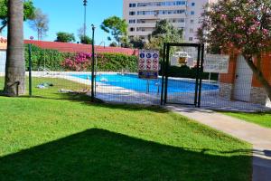 a fence next to a swimming pool in a park at El Encanto in Fuengirola