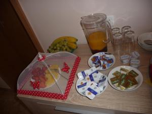 una mesa cubierta con comida, bebida y fruta en Pension Andrea, en Lugau