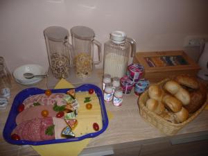 una mesa con un plato de comida y una cesta de pan en Pension Andrea, en Lugau
