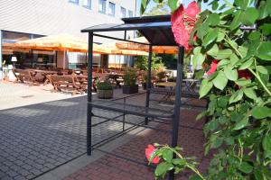 a black stand in front of a restaurant with roses at astral'Inn Leipzig Hotel & Restaurant in Leipzig