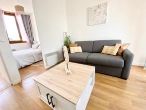 ein Wohnzimmer mit einem Sofa und einem Couchtisch in der Unterkunft Le Wood, entre centre ville et plage in Mers-les-Bains