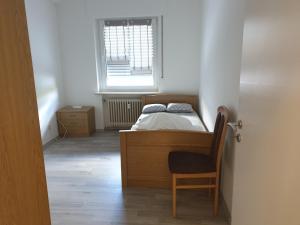 a bedroom with a bed and a chair and a window at Osterbrock EG Monteurwohnung in Geeste