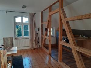 una sala de estar con una escalera de madera en una habitación en Ferienwohnung ehemalige Revierförsterei "uns Lütt", en Kuhstorf