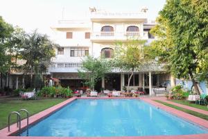 a swimming pool in front of a building at Hotel Meghniwas in Jaipur