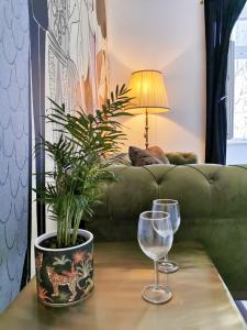 a table with two glasses and a potted plant at Litore in Pula