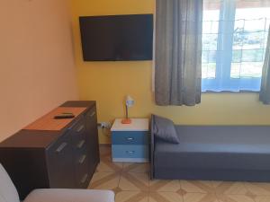 a bedroom with a bed and a desk and a tv at Domek w Górach in Lubawka