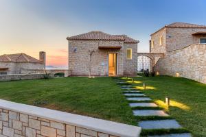 a brick house with a yard with a pathway at Caldera Theros Villas in Hersonissos