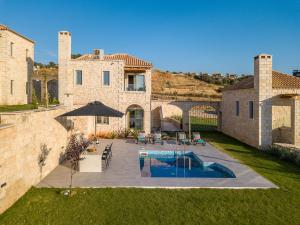 a house with a swimming pool in a yard at Caldera Theros Villas in Hersonissos