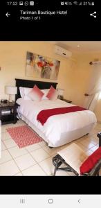 a bedroom with a large white bed with red pillows at Tariman Hotel in Durban