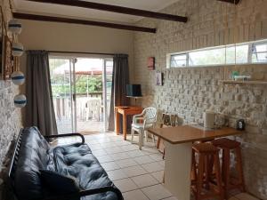 a living room with a couch and a table at Anchorage Cottage & The Moorings in Cape St Francis