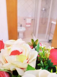 a bouquet of flowers in a bathroom with a sink at Bed and Breakfast La Guglia nel Salento in Galatina