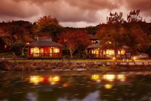 a house by the water with lights on at First Group Knysna River Club in Knysna